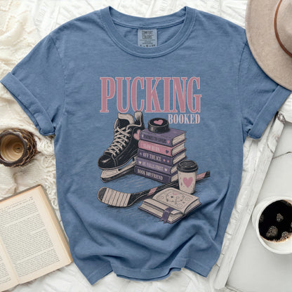 Blue t-shirt with "Pucking Booked" and book-themed hockey graphics.