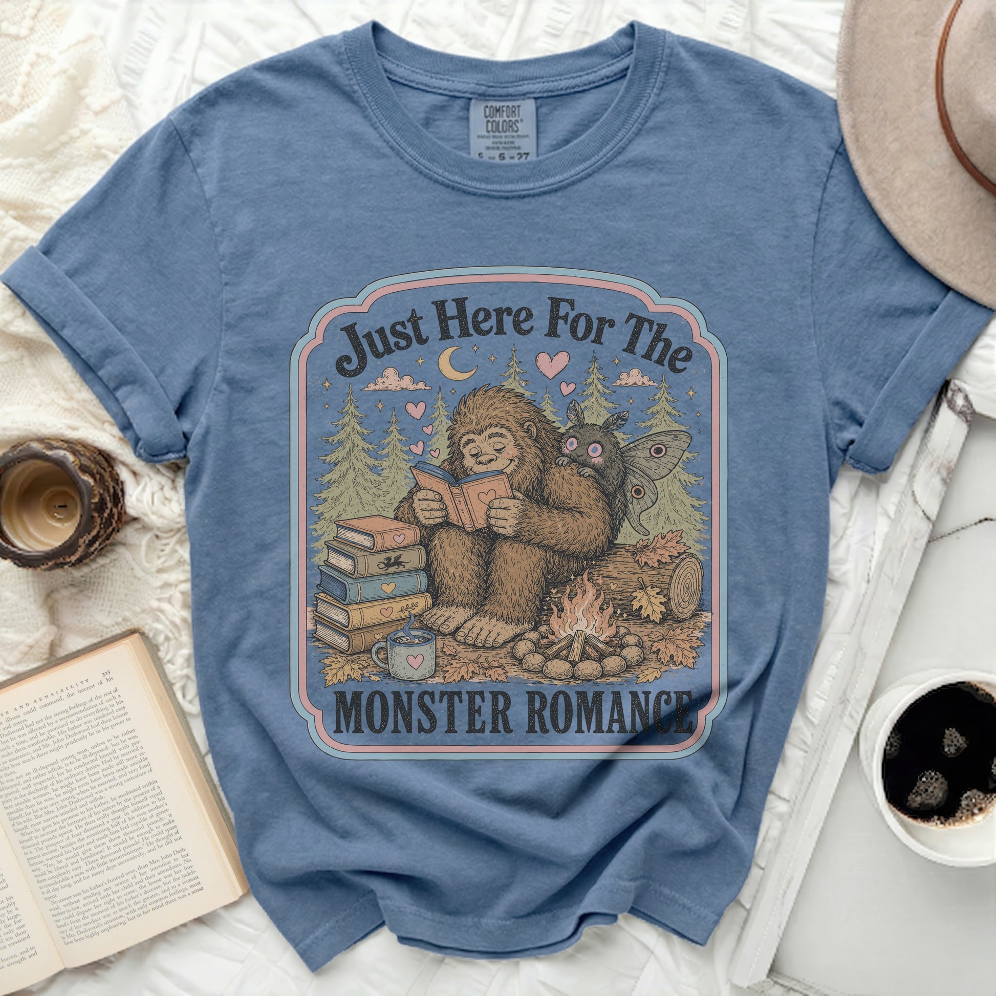 Bigfoot and moth reading by campfire with text "Just Here For The MONSTER ROMANCE"