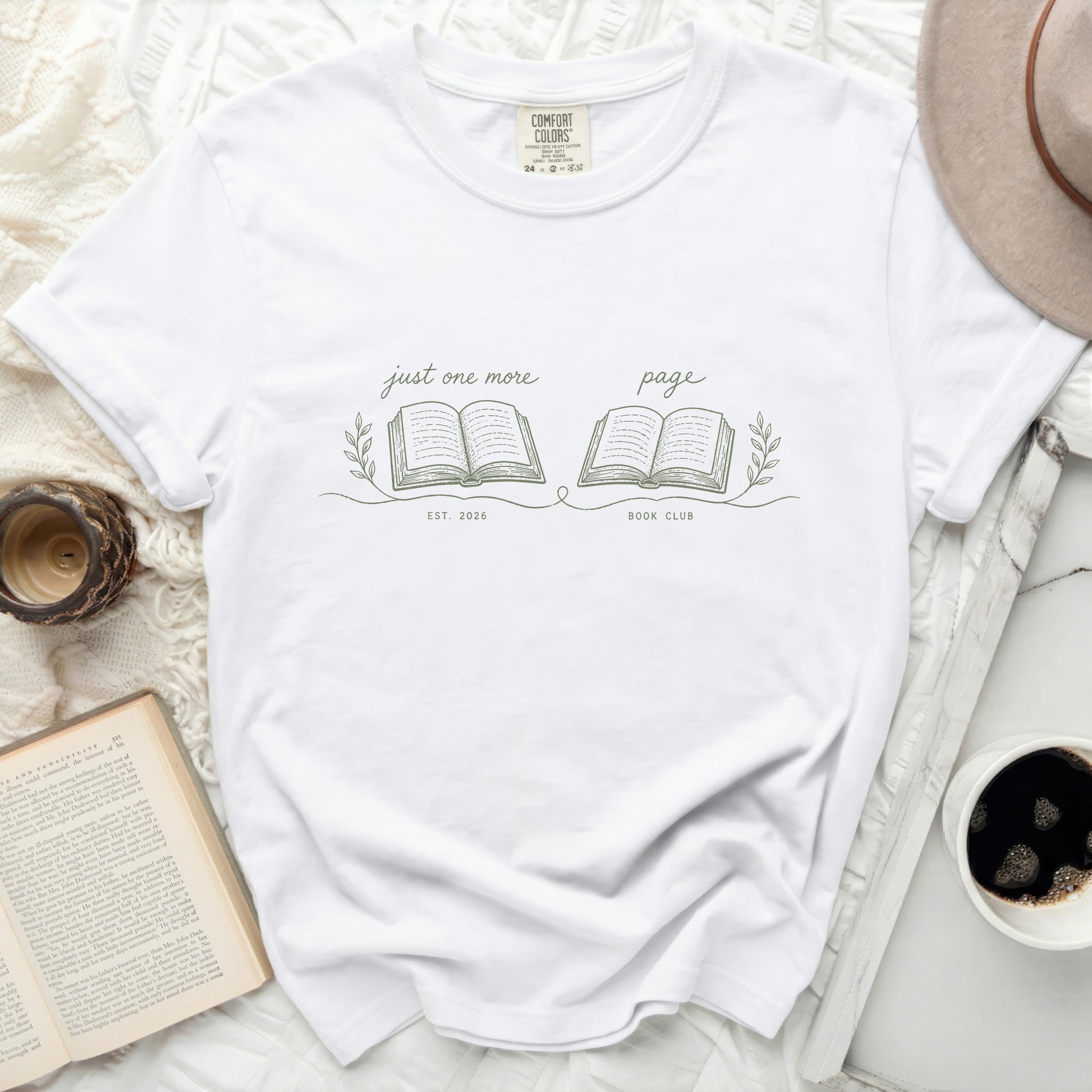 White t-shirt with "just one more page" and "BOOK CLUB EST. 2026" graphics.