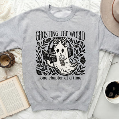 Grey sweatshirt with a graphic of a ghost reading and drinking, with text "GHOSTING THE WORLD one chapter at a time".