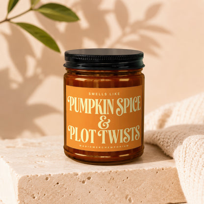 Amber jar candle labeled "Smells Like Pumpkin Spice & Plot Twists".