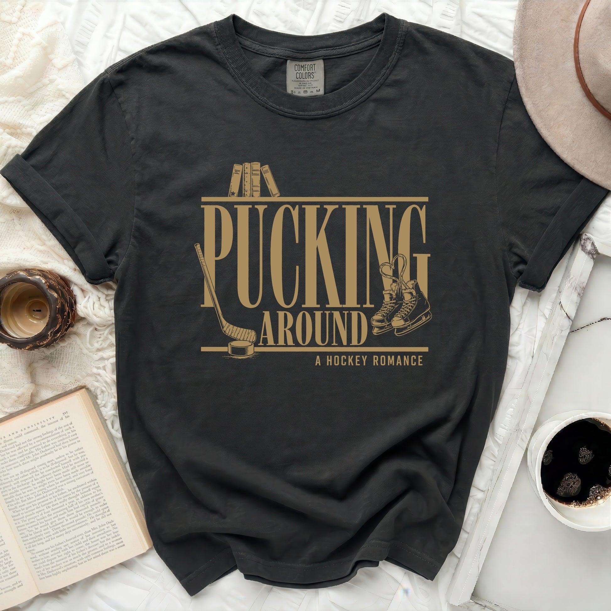 Black t-shirt with "Pucking Around A Hockey Romance" text and ice skates.