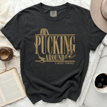 Black t-shirt with "Pucking Around A Hockey Romance" text and ice skates.