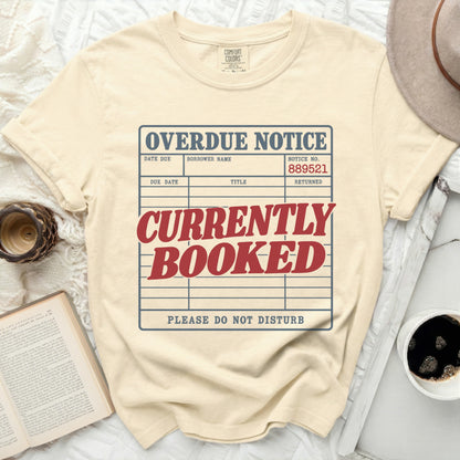 Cream t-shirt with "OVERDUE NOTICE" and "CURRENTLY BOOKED" design.