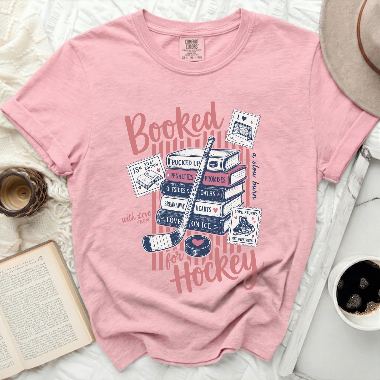 Pink t-shirt with "Booked for Hockey" text, books, and hockey graphics.