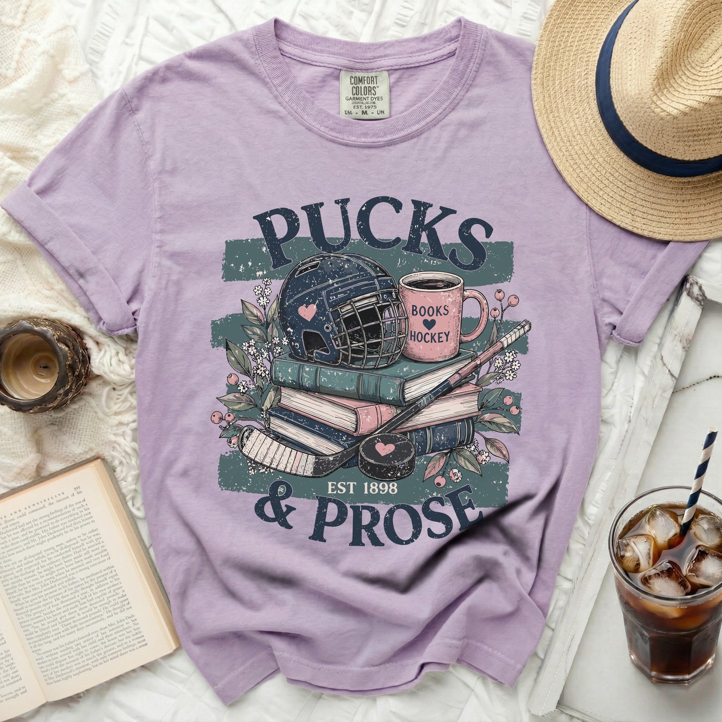 Purple t-shirt with "PUCKS & PROSE" hockey and book graphic.