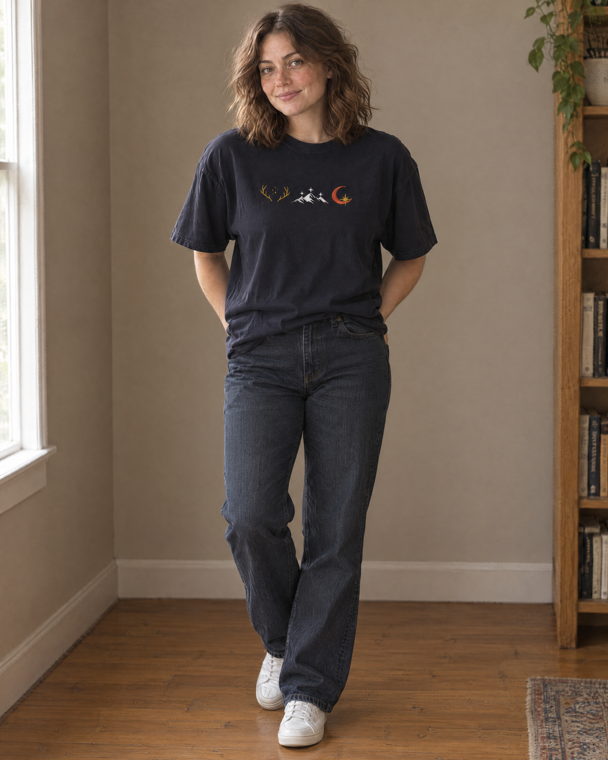 Full-length view of the True Navy tee, embroidered row of three emblems (golden antlers with stars, white mountains with stars, crescent moon with a gold star) on the chest