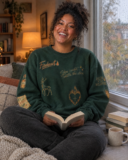 Aelin Fireheart Doodles Sweatshirt, by a rainy window with a book
