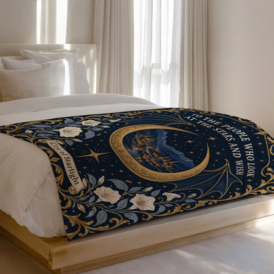 Velaris City of Starlight Crest Velveteen Plush Blanket on a bed