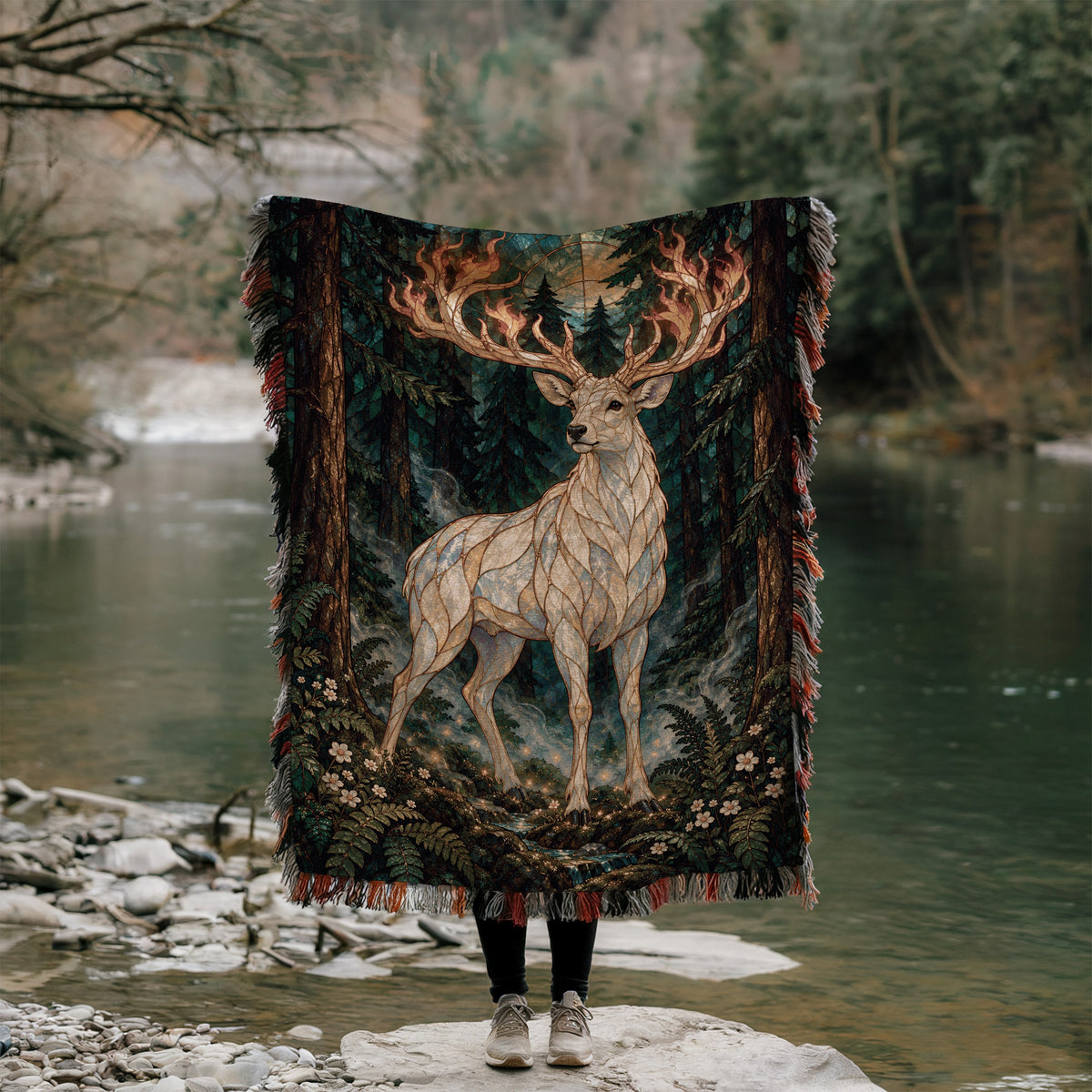 Terrasen Stag Woven Throw Blanket held up outdoors by a river