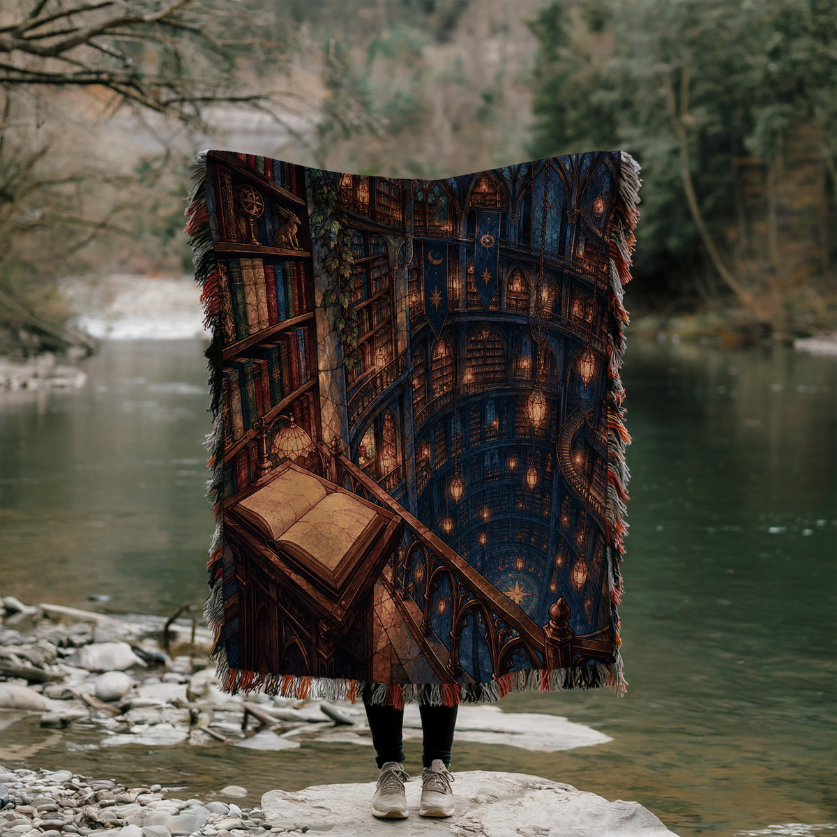 Midnight House of Wind Woven Throw Blanket held up outdoors by a river