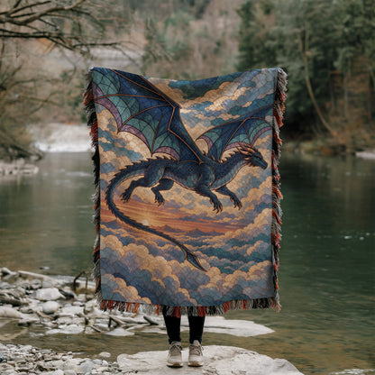 Sgaeyl Dragon Woven Throw Blanket held up outdoors by a river