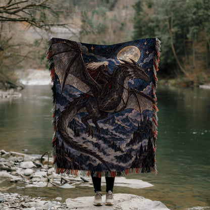 Above the Storm Woven Throw Blanket held up outdoors by a river