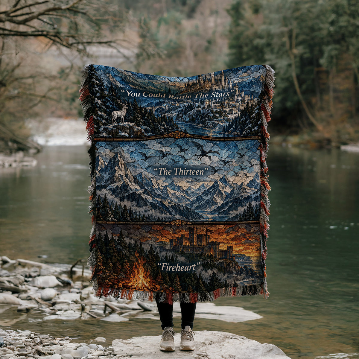 Terrasen Stained Glass Woven Throw Blanket held up by a river