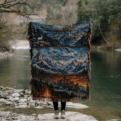 Terrasen Stained Glass Woven Throw Blanket held up by a river