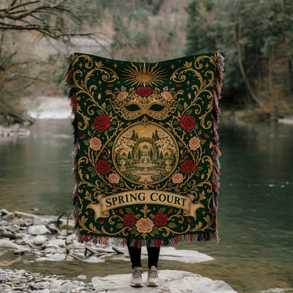 Spring Court Masquerade Crest Woven Throw Blanket held up by a river