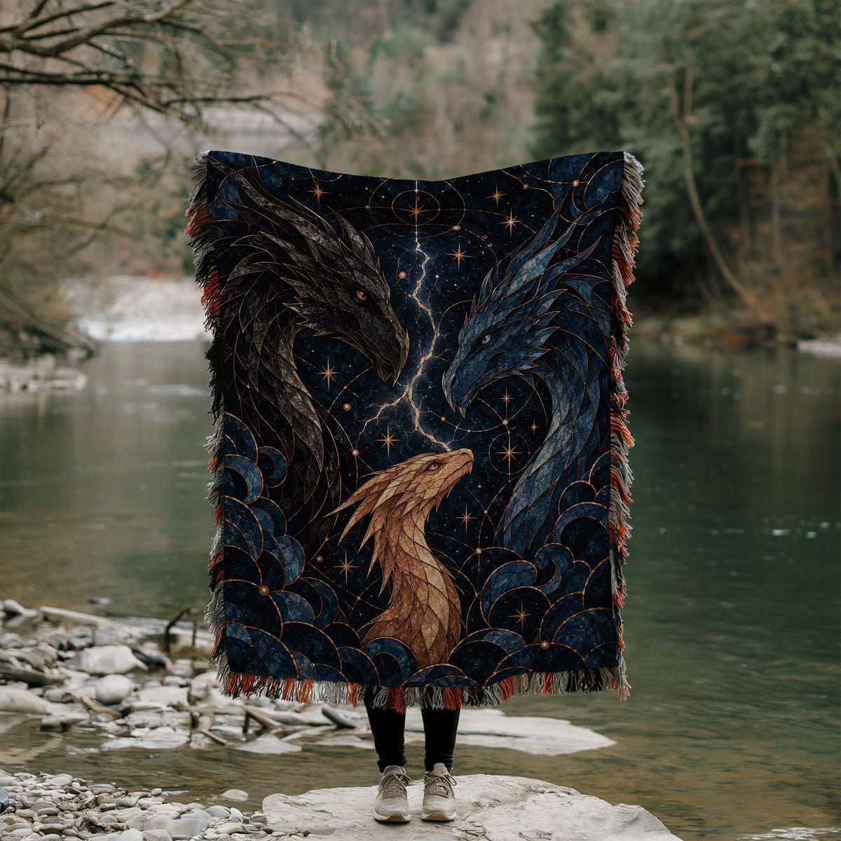 Dragon Bond Woven Throw Blanket held up outdoors by a river