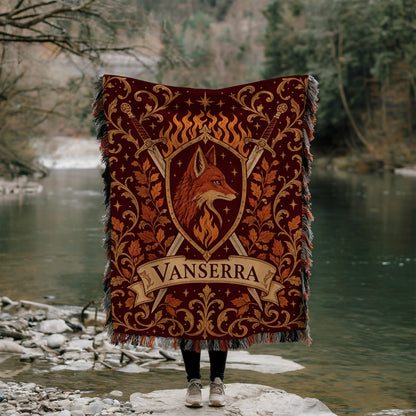 Vanserra Crest Woven Throw Blanket held up by a river