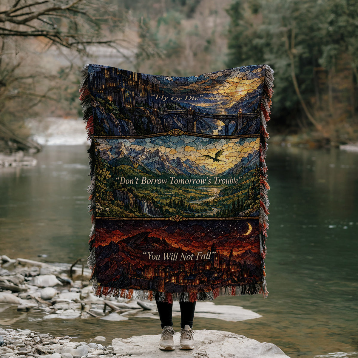 Empyrean Stained Glass Woven Throw Blanket held up by a river