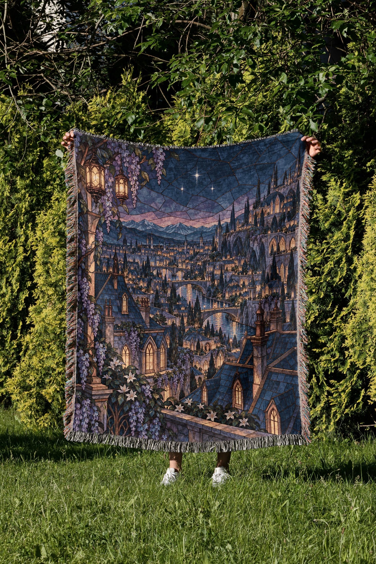 Velaris Rooftop Woven Throw Blanket held up in a garden