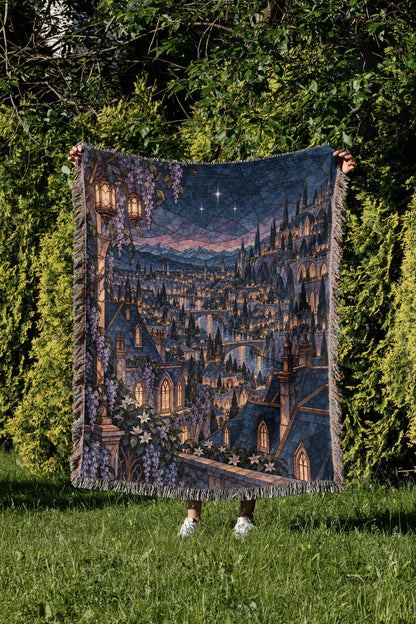 Velaris Rooftop Woven Throw Blanket held up in a garden