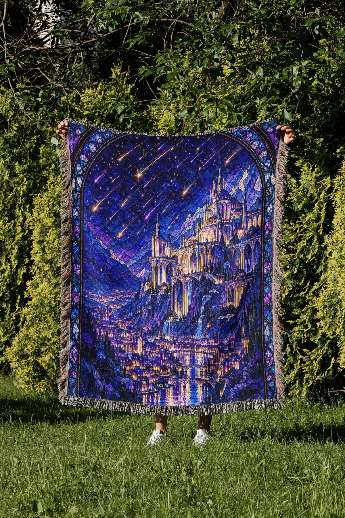Starfall over Velaris Stained Glass Woven Throw Blanket held up in a garden