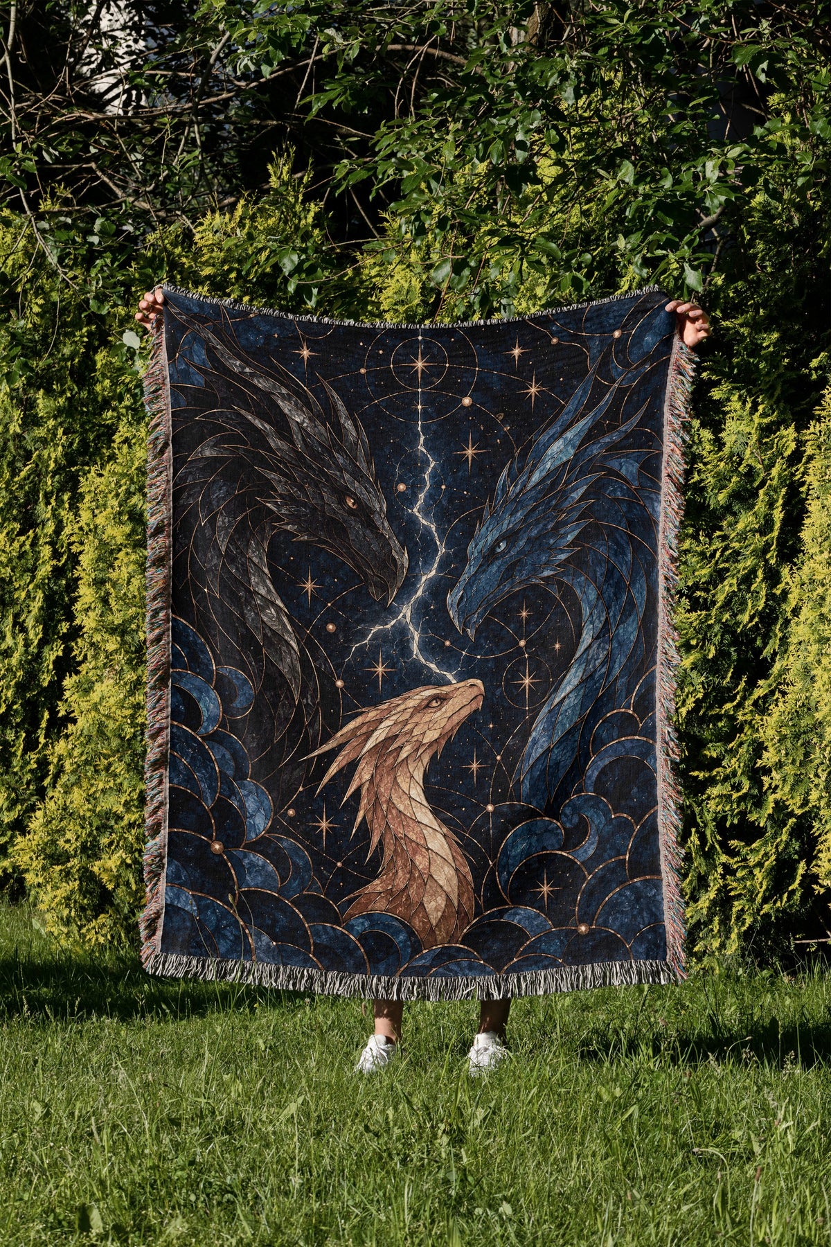 Dragon Bond Woven Throw Blanket held up in a garden
