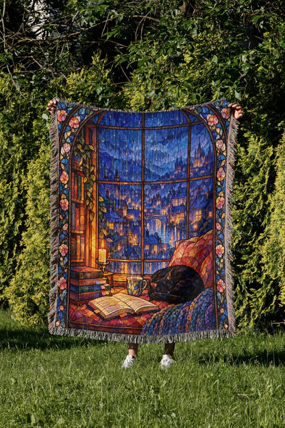The Reader's Window Stained Glass Woven Throw Blanket held up in a garden