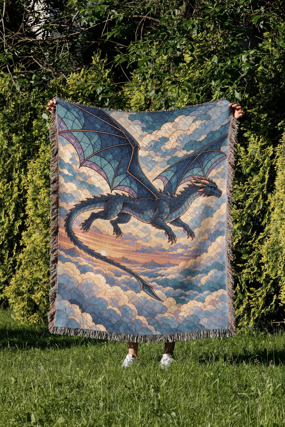 Sgaeyl Dragon Woven Throw Blanket held up in a garden