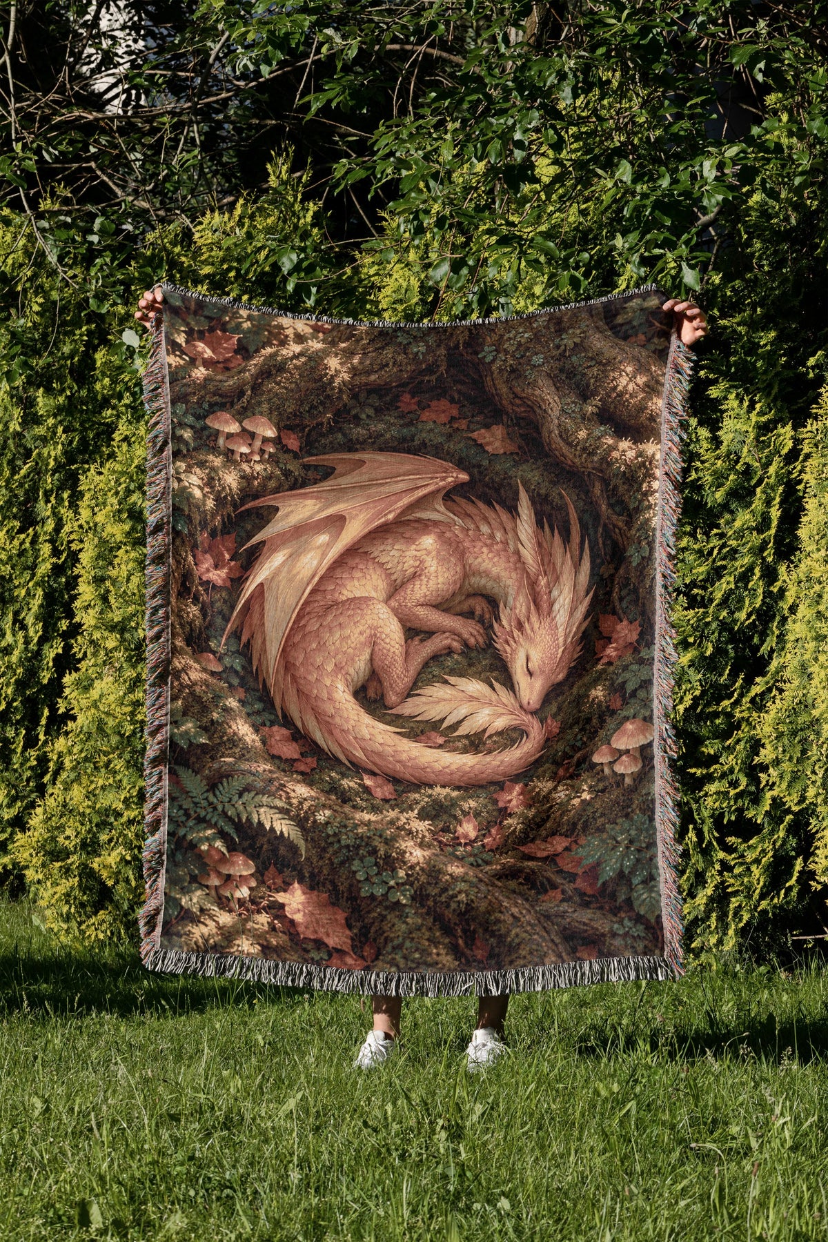 Golden Dragon Woven Throw Blanket held up in a garden