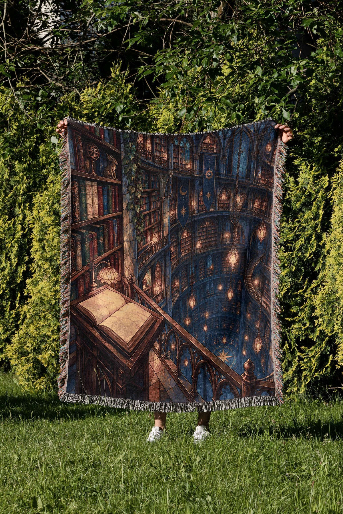 Midnight House of Wind Woven Throw Blanket held up in a garden