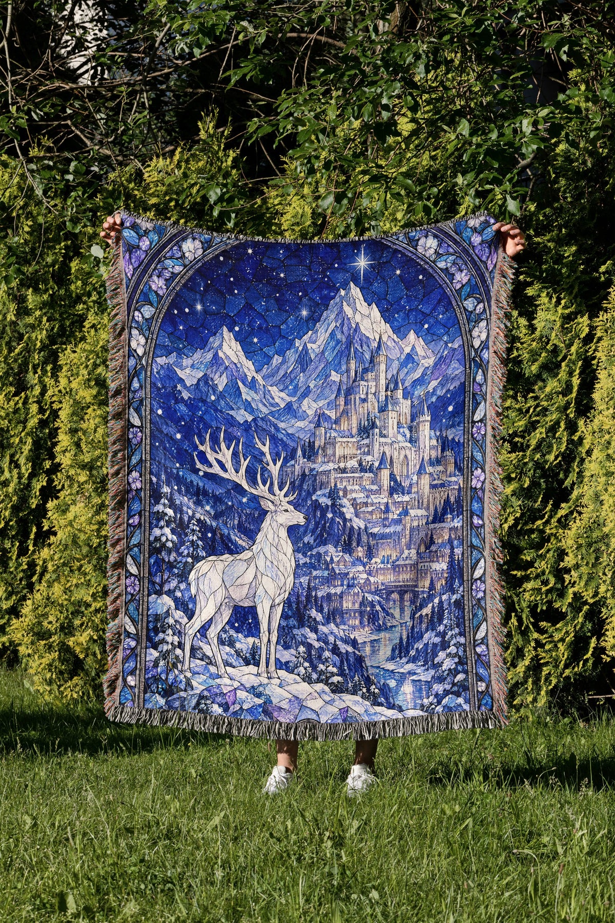 Orynth in Winter Stained Glass Woven Throw Blanket held up in a garden