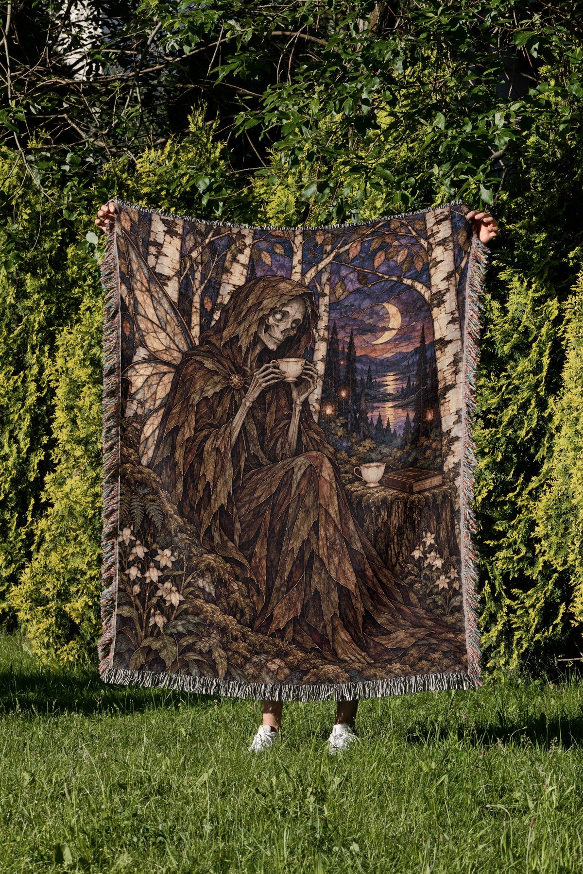 Suriel Tea Woven Throw Blanket held up in a garden