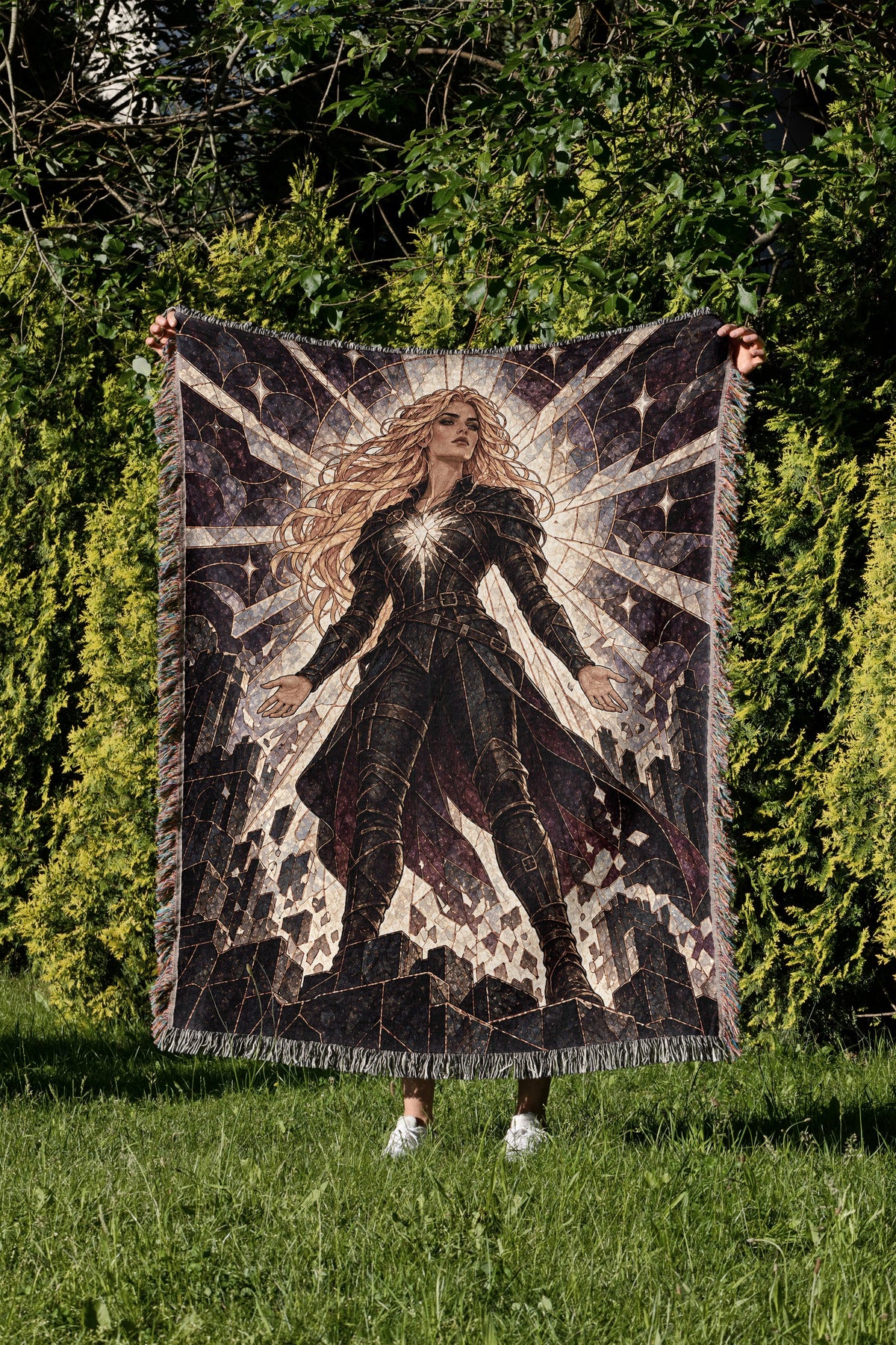 Asterin's Yielding Woven Throw Blanket held up in a garden