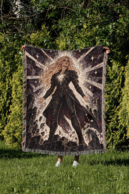 Asterin's Yielding Woven Throw Blanket held up in a garden