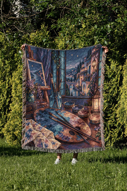 The Rainbow of Velaris Woven Throw Blanket held up in a garden