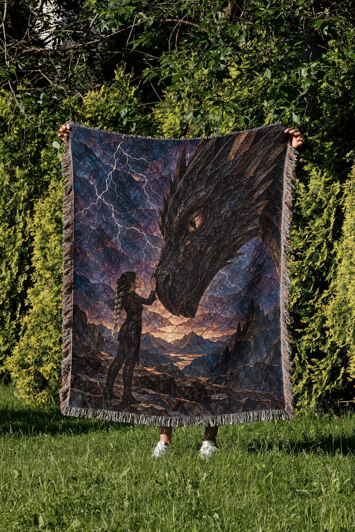 Dragon Rider Woven Throw Blanket held up in a garden