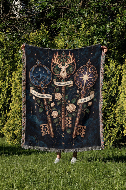 Bookish Maasverse Woven Throw Blanket held up in a garden
