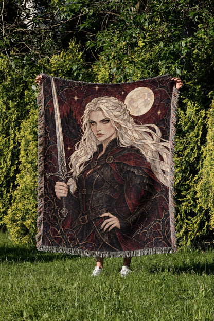 Iron Queen Woven Throw Blanket held up in a garden