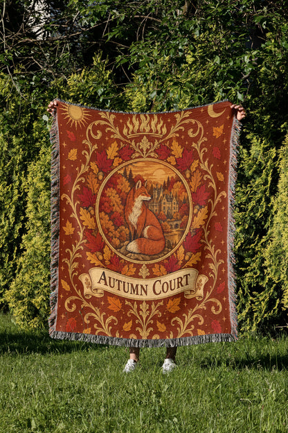 Autumn Court Fox Crest Woven Throw Blanket held up in a garden