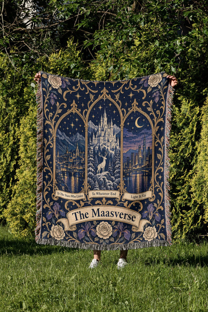 Maasverse Three Realms Crest Woven Throw Blanket held up in a garden