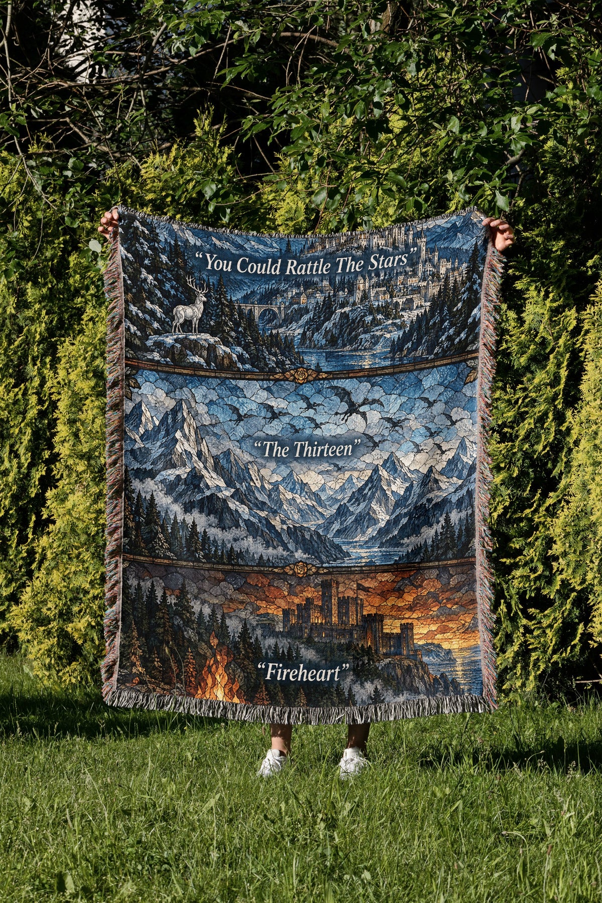 Terrasen Stained Glass Woven Throw Blanket held up in a garden