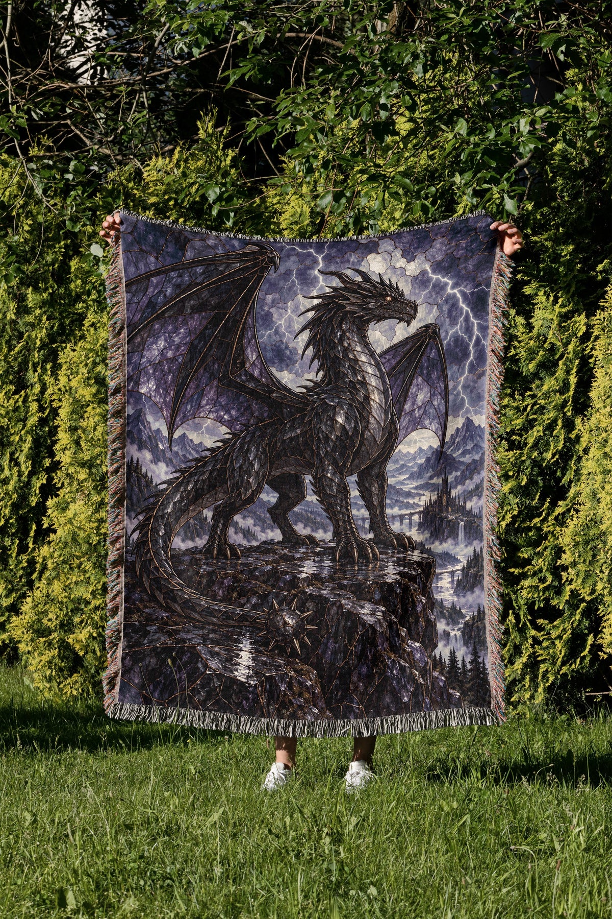 Storm Tairn Woven Throw Blanket held up in a garden