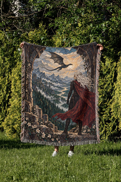 Wyvern at the Mountain Pass Woven Throw Blanket held up in a garden