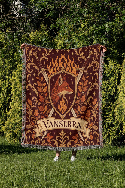 Vanserra Crest Woven Throw Blanket held up in a garden