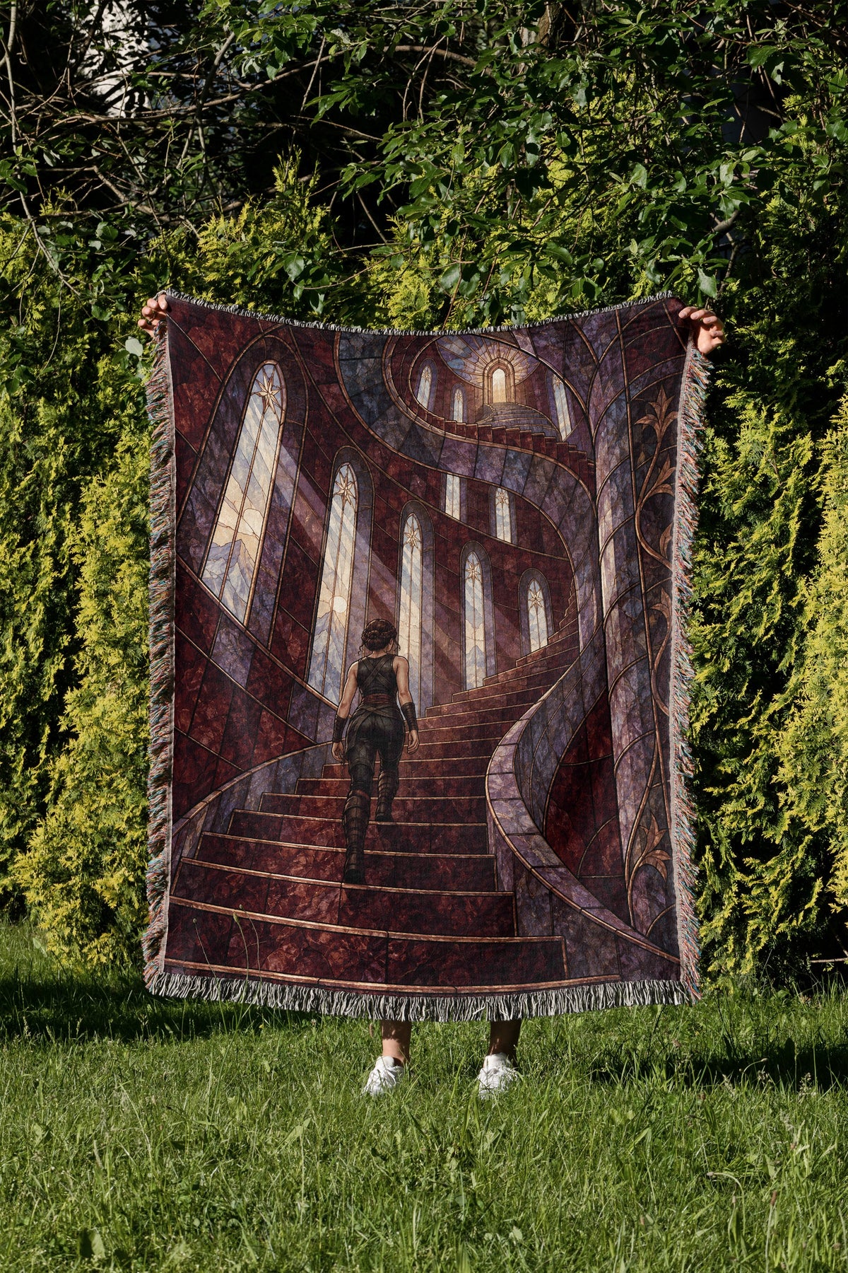 Nesta's Staircase Woven Throw Blanket held up in a garden