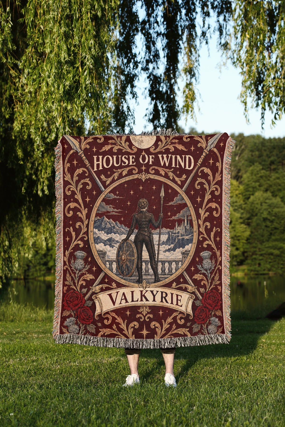 Valkyrie House of Wind Crest Woven Throw Blanket held up outdoors