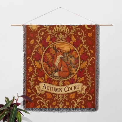 Autumn Court Fox Crest Woven Throw Blanket hanging on a wall with a plant