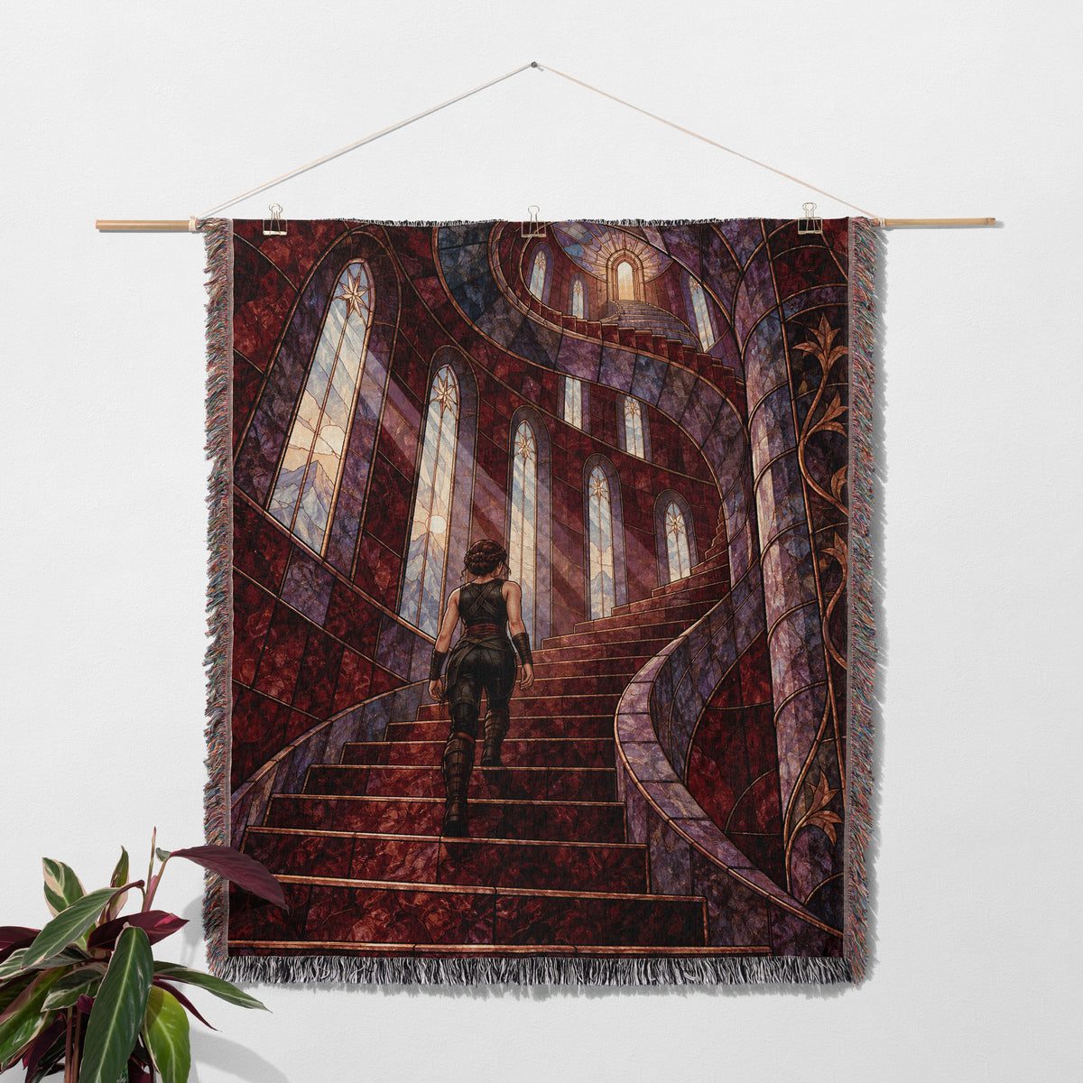 Nesta's Staircase Woven Throw Blanket hanging on a wall with a plant