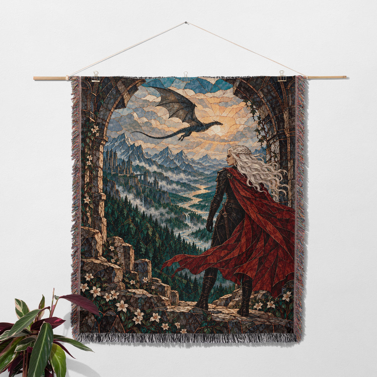 Wyvern at the Mountain Pass Woven Throw Blanket hanging on a wall with a plant